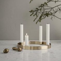 candles are arranged on a marble table with gold and white accents, including one candle holder