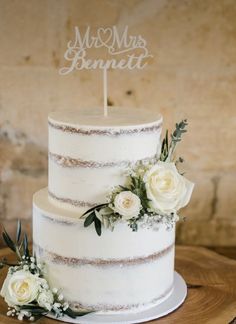 a white wedding cake with flowers on top