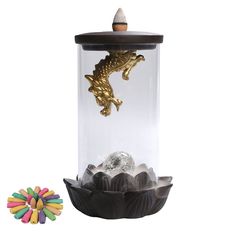 a glass jar filled with chocolates and a gold dragon figurine sitting on top of it