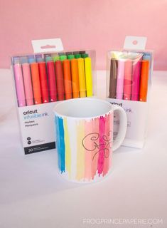 a coffee mug with crayons in it next to a box of markers