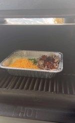 a grill that has some food on top of it and is being prepared to be cooked