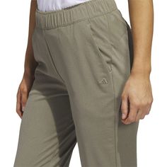 a woman in white shirt and khaki pants holding her hand on her hip