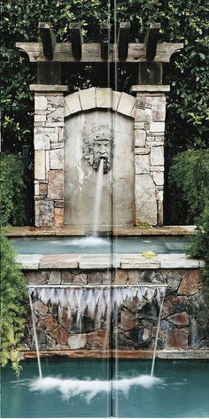 an open book showing a fountain with water coming out of it and trees in the background