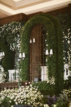 a room with flowers and greenery on the wall