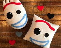 two pillows with faces and hearts on them