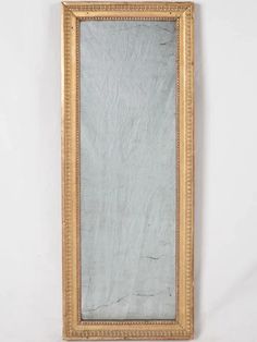 a gold framed mirror on a white wall