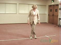 an older woman standing on top of a white line in front of a wooden door