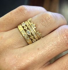 a close up of a person's hand with three rings on their fingers,