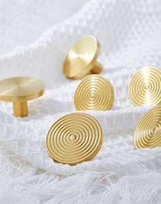 six gold knobs on a white blanket with one in the middle and four out