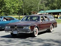 an old station wagon is parked on the side of the road next to another car