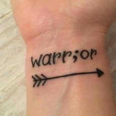 a wrist tattoo with the word warrior written on it and an arrow drawn in black ink