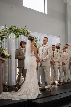 a bride and groom standing at the alter during their wedding ceremony in front of an audience