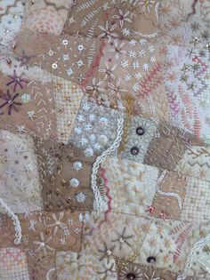 a close up view of an old quilt with many different colors and designs on it