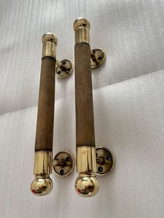 two brass and wood door handles on a white sheet