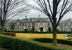 a large house with hedges in front of it