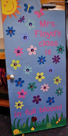 a classroom door decorated with flowers and the words, mrs floyd's class is in full bloom