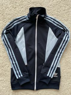 Blue Hooded Outerwear With Three Stripes, Adidas Blue Track Jacket For Streetwear, Blue Three Stripes Track Jacket For Fall, Retro Long Sleeve Track Jacket For Winter, Vintage Blue Outerwear For Sports, Adidas Blue Track Jacket For Spring, Blue Adidas Track Jacket For Spring, Blue Retro Track Jacket For Spring, Fitted Sports Outerwear With Three Stripes