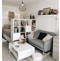 a living room filled with furniture next to a white table and bookshelf on top of a hard wood floor