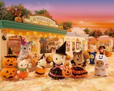 a group of stuffed animals dressed up in halloween costumes and pumpkins on the ground