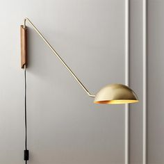 a wall light with a long arm and a wooden stick attached to it