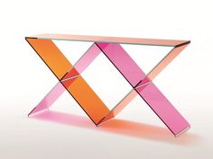 a pink and orange glass table sitting on top of a white floor