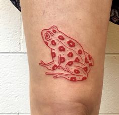 a red and white frog tattoo on the right thigh, with hearts in it's legs