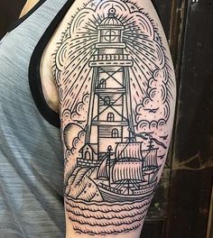 a man with a lighthouse tattoo on his arm