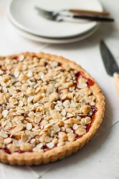 a pie sitting on top of a table next to a plate with utensils