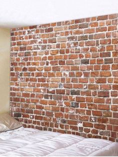 a bed sitting in front of a brick wall with no sheets on top of it