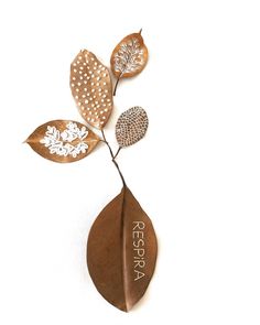 a metal wall hanging with three leaves and the words regora written on one side