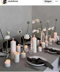 a table topped with lots of white flowers and candles