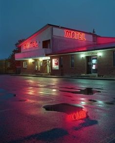 an empty motel with red neon lights on the front