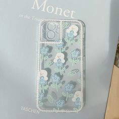 the phone case is designed to look like it has blue flowers on it and green leaves