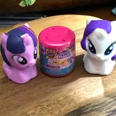 three little pony toys sitting on top of a wooden table