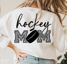 a woman wearing a sweatshirt that says hockey mom