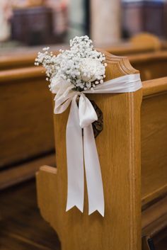 a bouquet of baby's breath sits on the pews of a wooden church