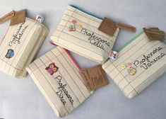 four pencil cases with writing on them and tags attached to the top of each one