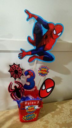 a spiderman birthday cake and cupcake topper