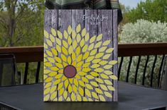 a yellow flower painted on a bag sitting on top of a table next to some chairs