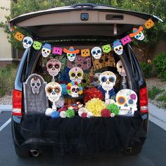 the back of a car decorated with sugar skulls and dia de los muerts decorations