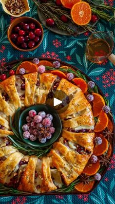 an orange and cranberry christmas cake on a platter surrounded by other holiday foods