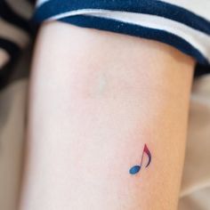 a small musical note tattoo on the right side of the thigh, which is blue and red