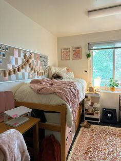 a bed room with a neatly made bed and a rug on the floor in front of a window