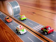 three toy cars are driving down the road with tape on them as if they were racing