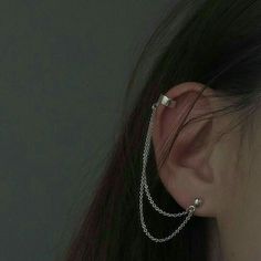 a close up of a person's ear with chains attached to the back of it