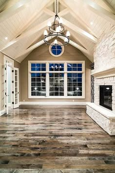 a large living room with stone fireplace and vaulted ceiling