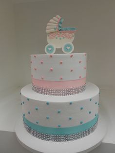 a three tiered cake with a baby carriage on top