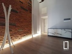 an empty room with wooden floors and brick walls