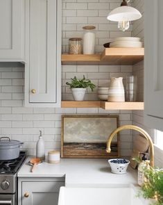 a kitchen with white cabinets and open shelves