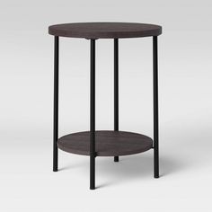 a round table with black metal legs and a wooden shelf on one side, against a white background